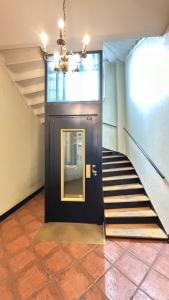 a hallway with a black door and stairs at Oslo-Frogner in Oslo