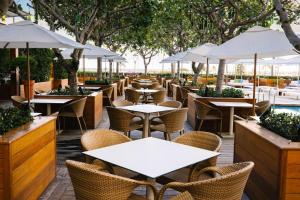 un restaurante con mesas, sillas y sombrillas en Hilton Vacation Club The Modern Honolulu, en Honolulu