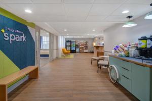 a lobby of a spark store with a counter and chairs at Spark By Hilton Rochester University Area in Rochester