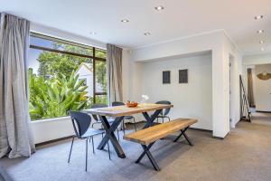 uma sala de jantar com uma mesa e cadeiras e uma janela em Entire house with pool, spa em Auckland