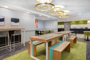 a waiting room with tables and chairs and a bar at Spark By Hilton Rochester University Area in Rochester