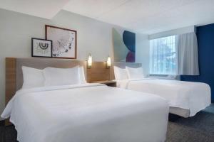 羅切斯特的住宿－紐約州羅切斯特大學區麗怡酒店，酒店客房设有两张床和窗户。