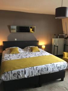 a bedroom with a large bed with two yellow pillows at B&B De Kaai in Nieuwpoort