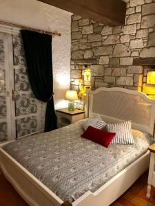 a bedroom with a large bed with a stone wall at VİA PERLA BUTİK OTEL in Çiftlikköyü