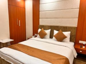 1 dormitorio con 1 cama grande con almohadas marrones y blancas en HOTEL EDEN GARDEN en Āsansol
