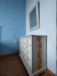 um quarto azul com uma cómoda e uma imagem na parede em Grammatikis house em Vourliótai
