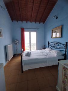 Schlafzimmer mit einem Bett und einem Fenster in der Unterkunft Grammatikis house in Vourliótai