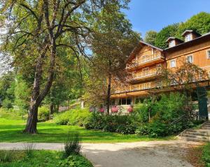 een groot huis met een boom ervoor bij Hotel Maria & Spa in Szczawnica