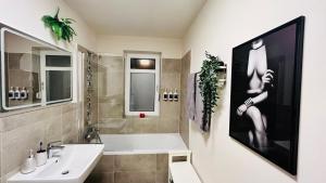 een badkamer met een wastafel, een bad en een wastafel bij Best Place to Stay - Dresden in Bannewitz