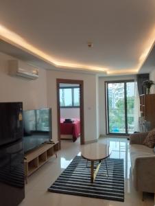 een woonkamer met een bank, een tv en een tafel bij Laguna Beach Resort 3 The Maldives in Jomtien Beach