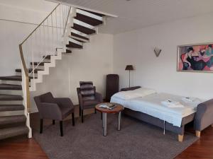 a bedroom with a bed and a staircase with chairs and a table at Hotel Friederike in Mülheim an der Ruhr