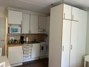 eine Küche mit weißen Schränken und einem Herd in der Unterkunft Trivsam 1 a in Mariehamn