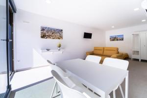 a white dining room with a white table and chairs at Ca la Mar Villajoyosa in Villajoyosa