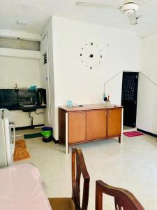 Habitación con escritorio y reloj en la pared en Shehan Villa, en Beruwala
