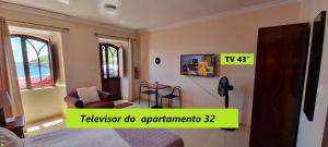 a room with a bed and a tv on a wall at Príncipe de Mónaco Boutique House in Angra do Heroísmo