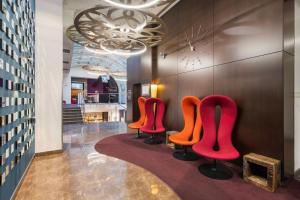 a row of red chairs in a lobby at Ikonik Parlament in Budapest