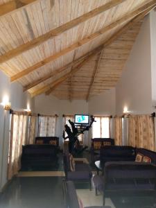 a living room with couches and a flat screen tv at Ngorongoro Camp and Lodge in Karatu