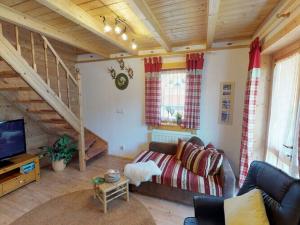 een woonkamer met een bank en een trap bij Holiday home our little hunting lodge in Philippsreut