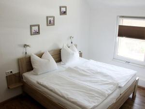 een bed met witte lakens en kussens in een slaapkamer bij Holiday apartment Villa Sonja 