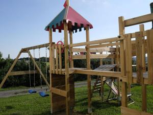 a wooden playground with a swing and a slide at Apartment in Schwalbenhof farm 