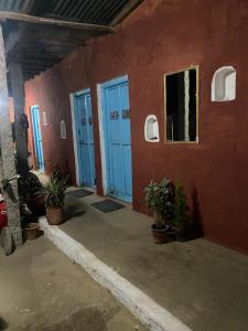 ハンピにあるPeshagar Guest Houseの青い扉と鉢植えの植物がある建物