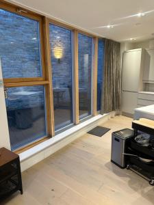 a room with large windows and a room with a table at Central London penthouse apartment in London