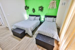 a bedroom with two beds and a green wall at A Casa de Isaura in Camariñas