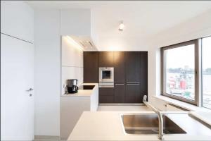 een witte keuken met een wastafel en een raam bij Dreamloft in Antwerpen