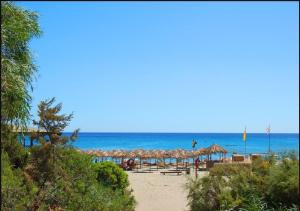 a beach with chairs and umbrellas and the ocean at Villetta Indipendente Sardegna in Villaputzu