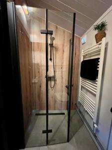 a shower with a glass door in a room at NEW - Private Cabin - on a lake near Amsterdam in Vinkeveen