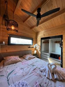 a bedroom with a bed and a ceiling fan at NEW - Private Cabin - on a lake near Amsterdam in Vinkeveen