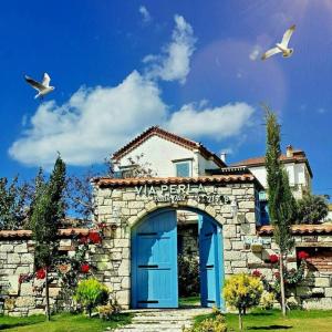 a building with a blue door and two birds at VİA PERLA BUTİK OTEL in Çiftlikköyü