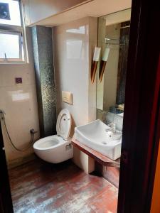 a bathroom with a toilet and a sink at HOTEL RK REGENCY in Ahmedabad