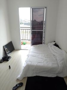 Un pat sau paturi într-o cameră la Aconchego Hostel