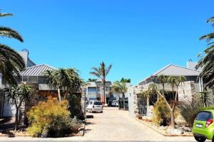 a street of houses with palm trees and cars at 1 Bedroom Apartment Tygervalley in Cape Town