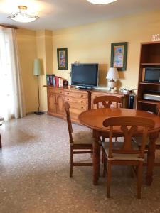 ein Wohnzimmer mit einem Tisch und einem TV in der Unterkunft Apartamento en la Playa Canet, muy cerca de Valencia in Canet d'en Berenguer