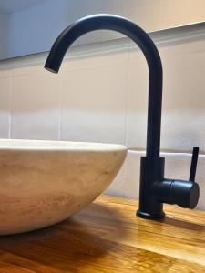 lavabo con grifo negro en el suelo de madera en Hôtel de la Mer, en Hyères