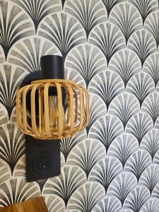 a lamp in front of a wall with a wallpaper at Hôtel de la Mer in Hyères