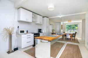 a kitchen with white cabinets and a wooden counter top at Vivid house in Wembley Downs in Perth