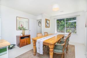 a dining room with a wooden table and chairs at Vivid house in Wembley Downs in Perth