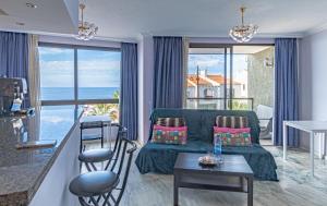 een woonkamer met een bank en een tafel bij Oceanfront Santiago Apt by Dream Homes Tenerife in Puerto de Santiago