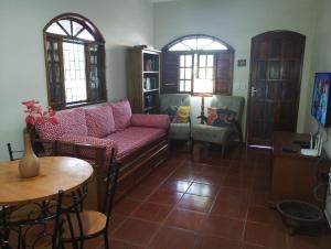a living room with a couch and a table at Pouso Zen in Araruama
