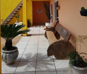einen Flur mit Bänken und Topfpflanzen in einem Gebäude in der Unterkunft Pousada Cactos in Chapada dos Guimarães