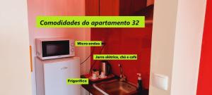 ein Badezimmer mit einer Mikrowelle, einem Waschbecken und einem Kühlschrank in der Unterkunft Príncipe de Mónaco Boutique House in Angra do Heroísmo
