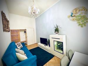 ST Apartment في فيينا: غرفة معيشة بها أريكة زرقاء وتلفزيون