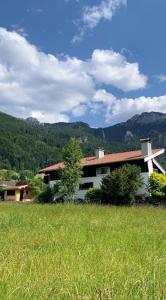 a house in the middle of a grassy field at Moderne Ferienwohnung mit großem Balkon in Aschau im Chiemgau