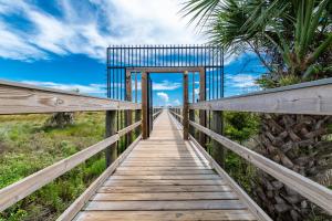a wooden bridge over a field with a palm tree at Ocean Village Club E15 in Saint Augustine +40 photos