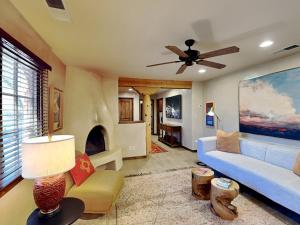uma sala de estar com um sofá azul e uma ventoinha de tecto em Puerta De Alameda em Santa Fé