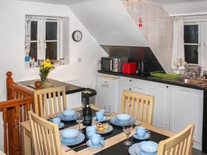 uma cozinha com uma mesa com pratos azuis em Iris Apartment em Stalham