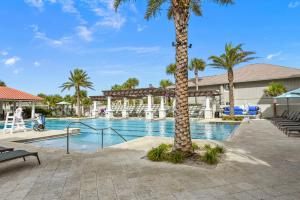 - une piscine dans un complexe avec des palmiers dans l'établissement Sunrise Villa, à Ponte Vedra Beach